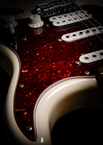 Dettaglio di chitarra elettrica Fender in luce drammatica