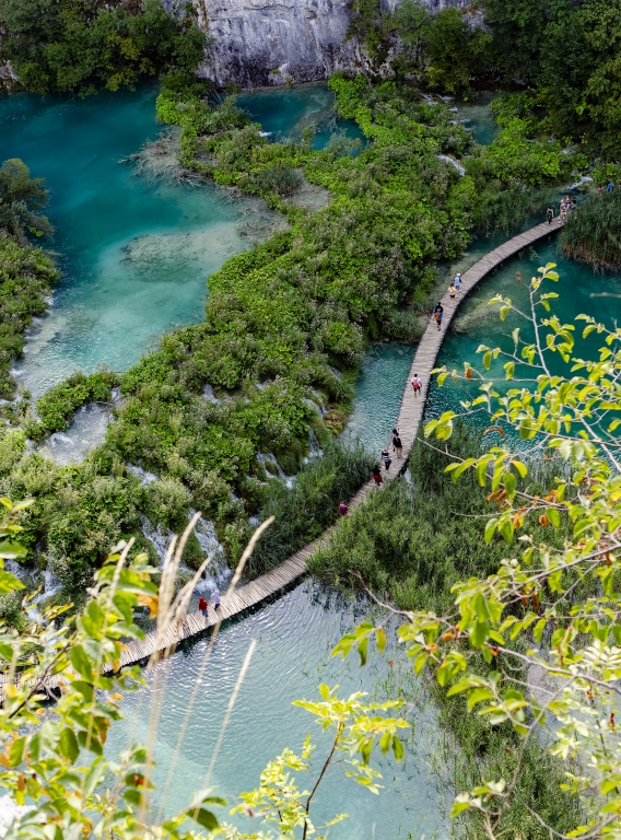 Passerella in legno sopra laghi turchesi immersi nella natura