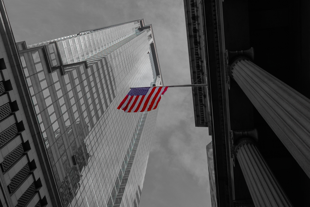 Bandiera americana tra i grattacieli – New York in bianco e nero