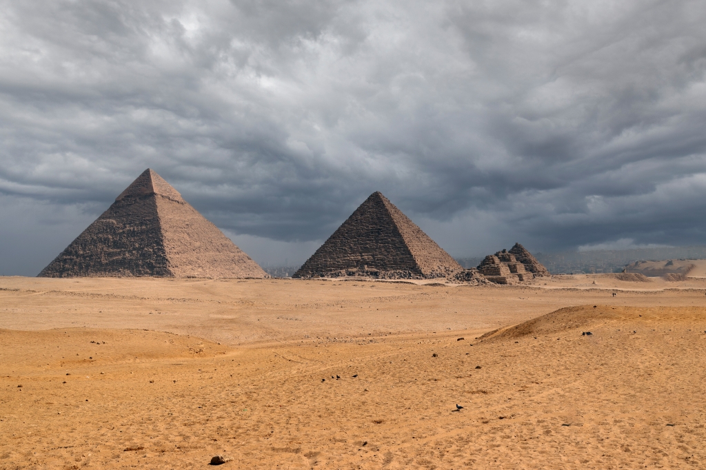 Le piramidi di Giza nel deserto sotto nuvole temporalesche