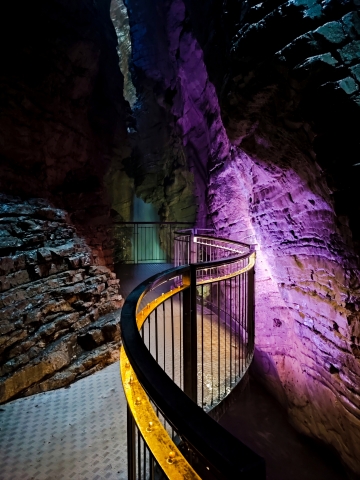Sentiero nella Grotta con Luci Viola e Gialle