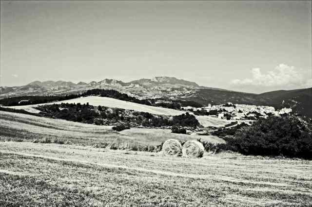 Borrello: paesaggio agricolo con borgo, montagne e balle di fieno