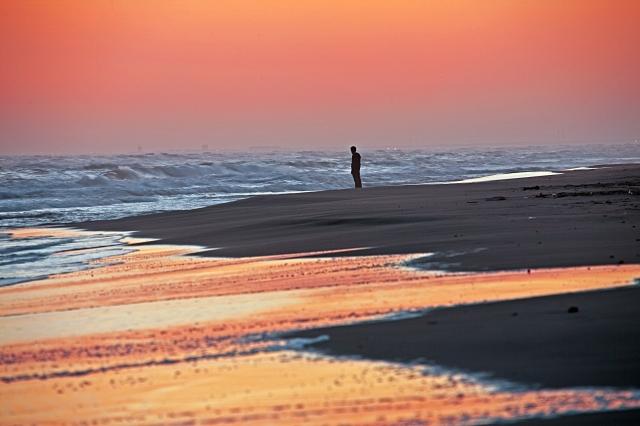 Tramonto con persona pensierosa. un mare immerso nei colori · claudio