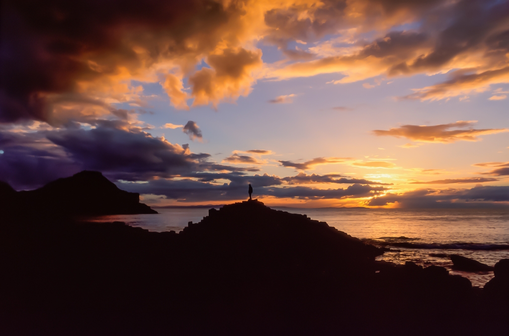 The silhouette of a man in the natural scenery at sunset