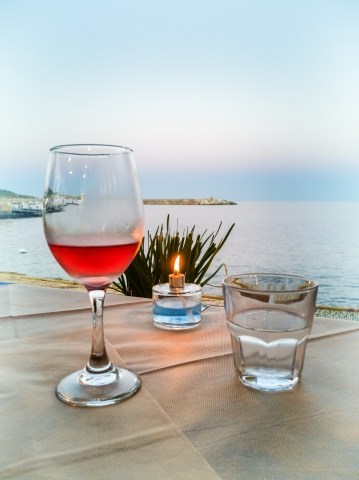 Bicchiere di vino, acqua e candela