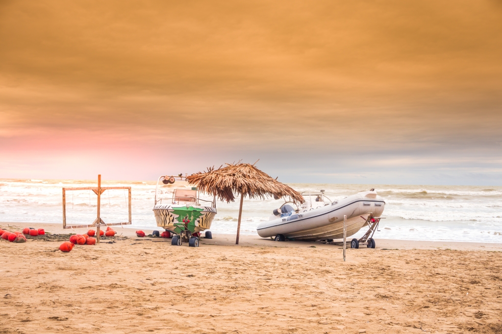 Motoscafo su spiaggia al tramonto