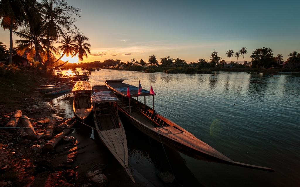 Long Boats at sunset over Mekong River