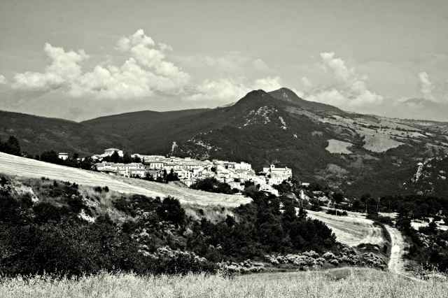 Borrello: paesaggio agricolo con borgo, montagne e nuvole