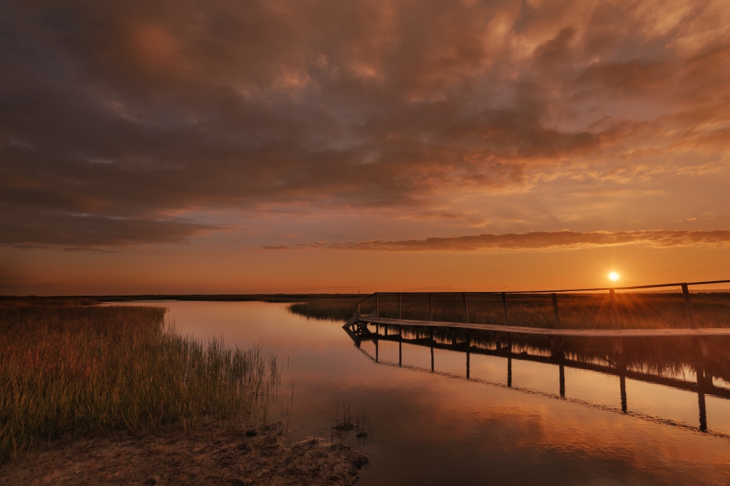 wooden pier on a volcanic pond at sunset