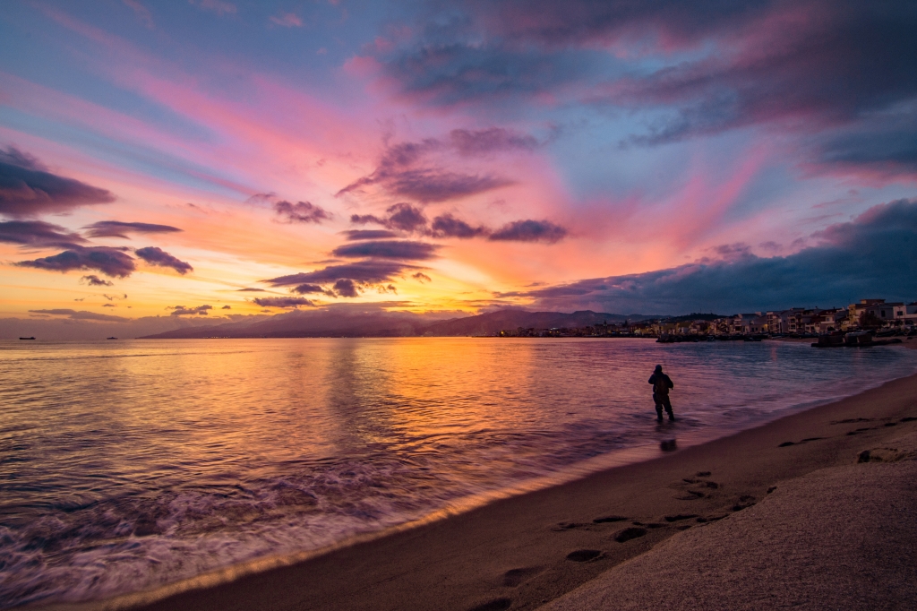 Pescatore al tramonto cielo infuocato