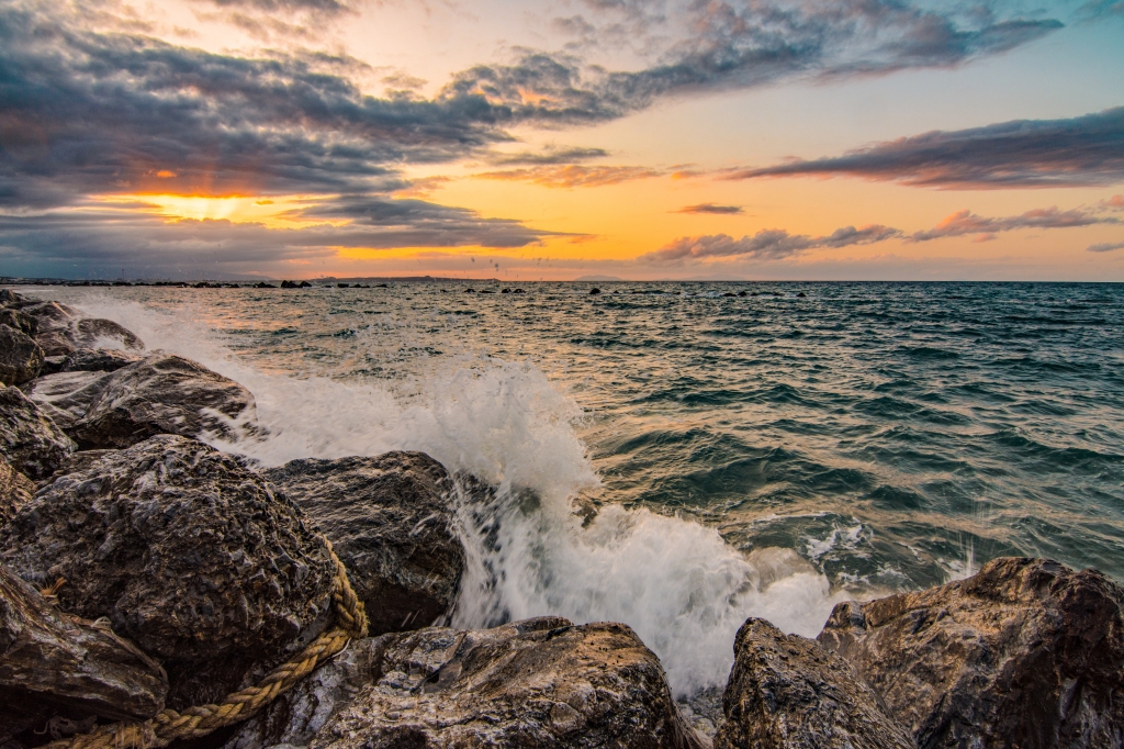 Onda sulla roccia tramonto spettacolare raggi di luce