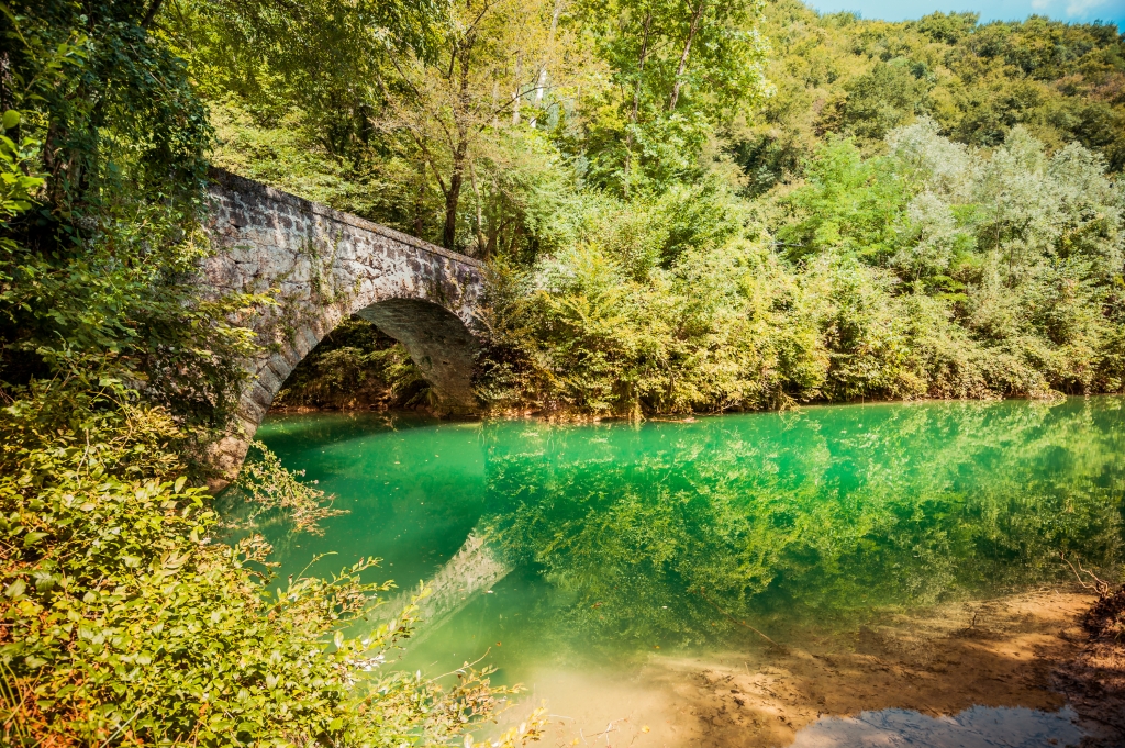 Ponte romano in mezzo al verde.