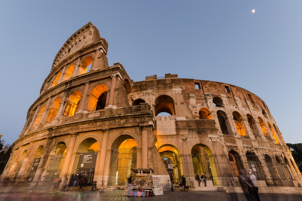 La maestosità del Colosseo visto dal basso e la luna nel cielo