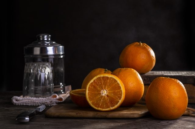 Oranges on wooden table with a dark background