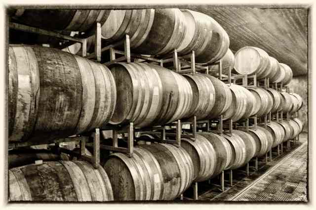 Foto in biano e nero della cantina con botti. · adrianobussi