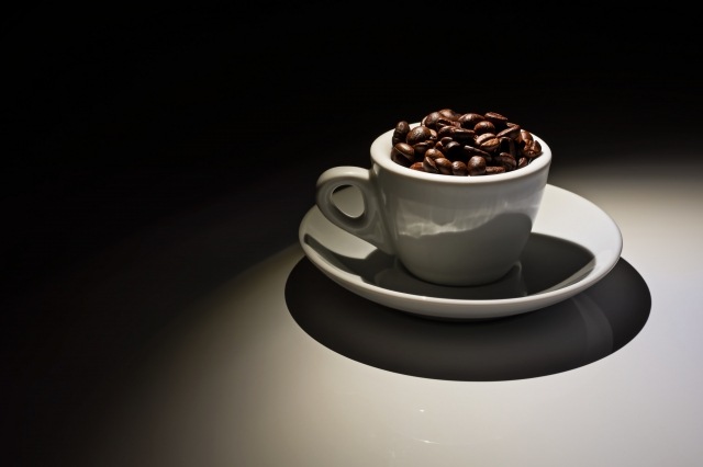 coffee cup full of roasted coffee beans
