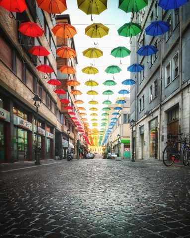 Via cittadina  con ombrelli colorati