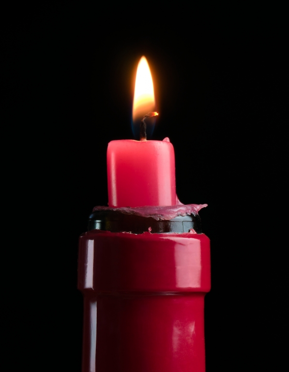 A red candle in a red wine bottle