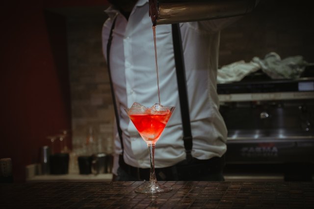 professional bartender prepares a cocktail in the martini glass