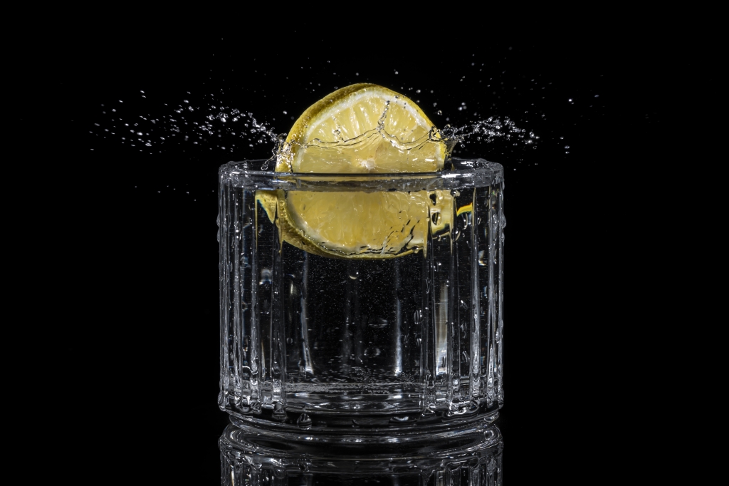 Un limone cade in un bicchiere