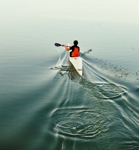Giovane atleta in canoa sull'acqua calma