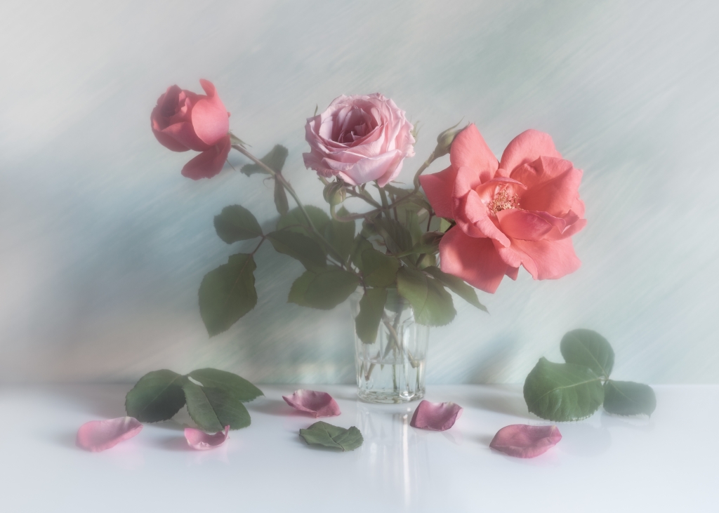 Roses in a glass in light colors.