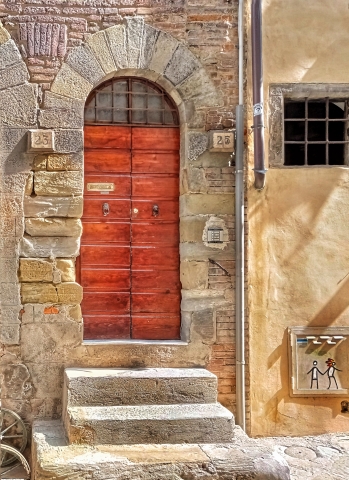 Ritratto di porta arancione nel sole della Toscana